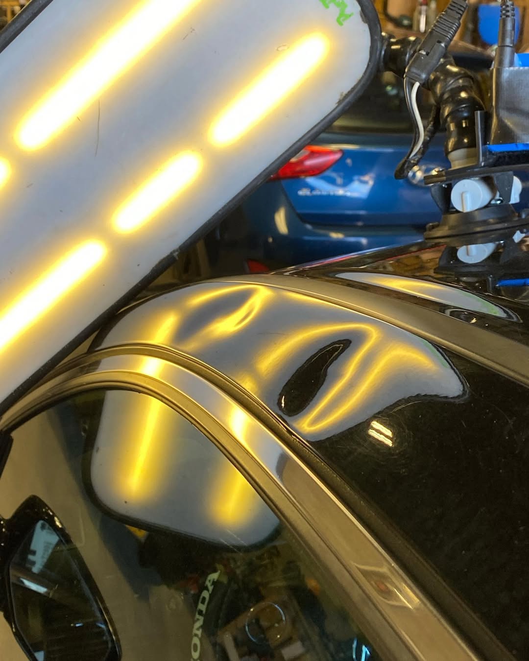 Dent in light metallic silver car door, close-up