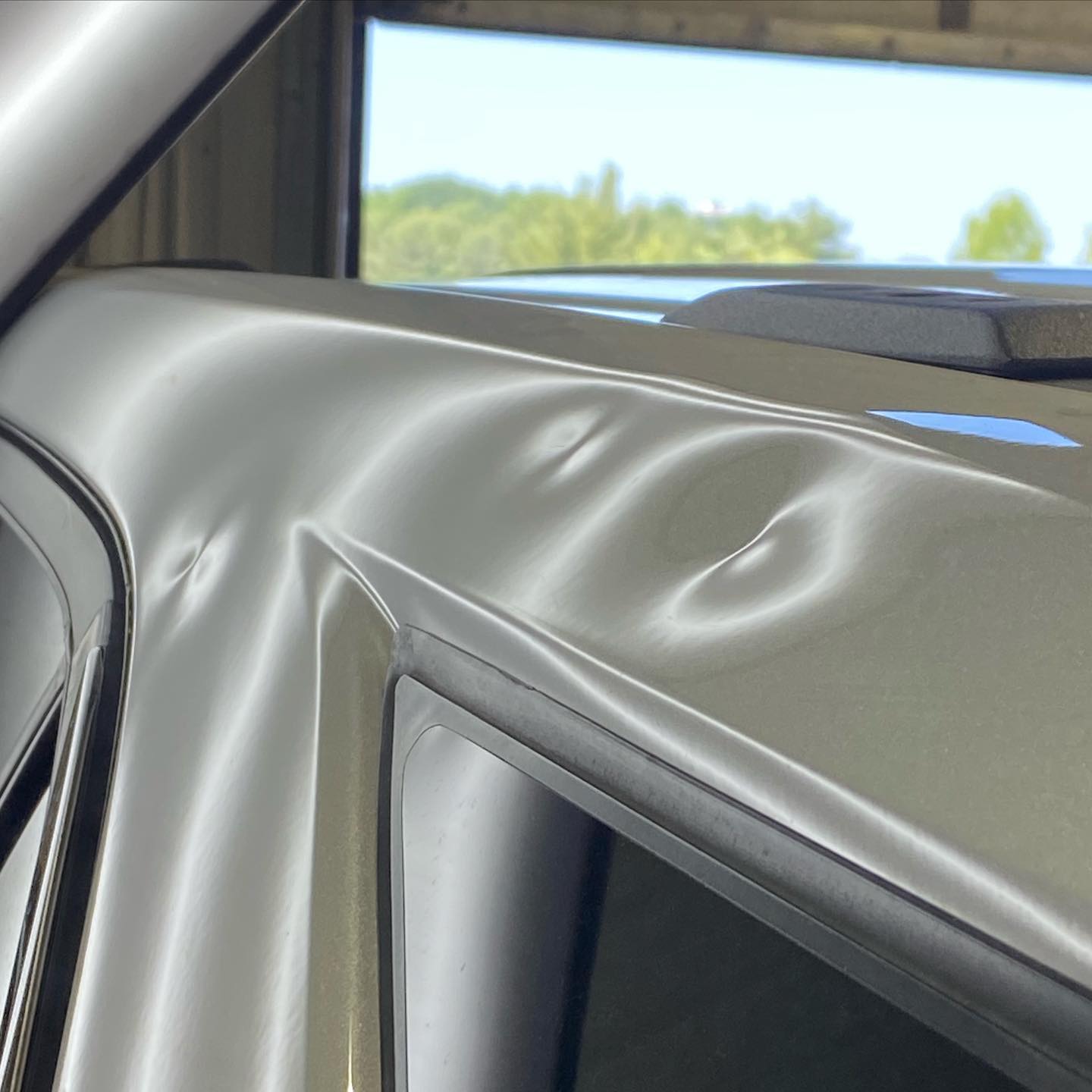 Light metallic silver car door with dent and scratches